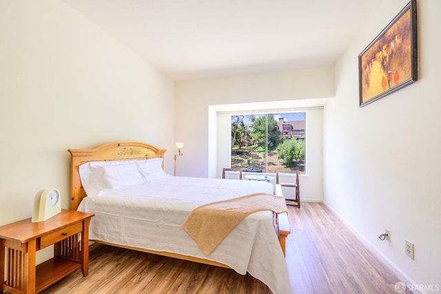 bedroom with wood finished floors and baseboards