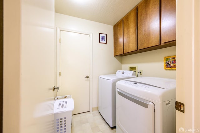 clothes washing area featuring cabinet space, washer and dryer, a textured ceiling, and light floors
