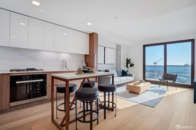 kitchen with light hardwood / wood-style flooring, appliances with stainless steel finishes, sink, and white cabinetry