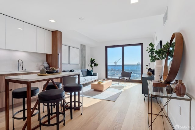 kitchen with light hardwood / wood-style floors, sink, and white cabinets