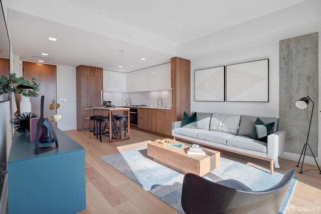 living room with light hardwood / wood-style flooring and sink