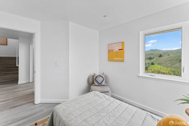 bedroom with wood finished floors and baseboards