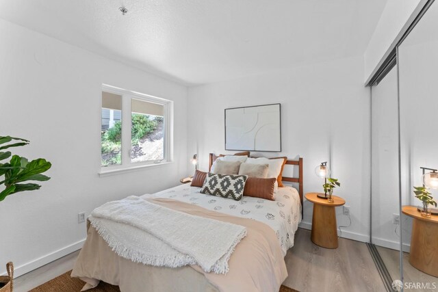 bedroom featuring a closet, baseboards, and wood finished floors