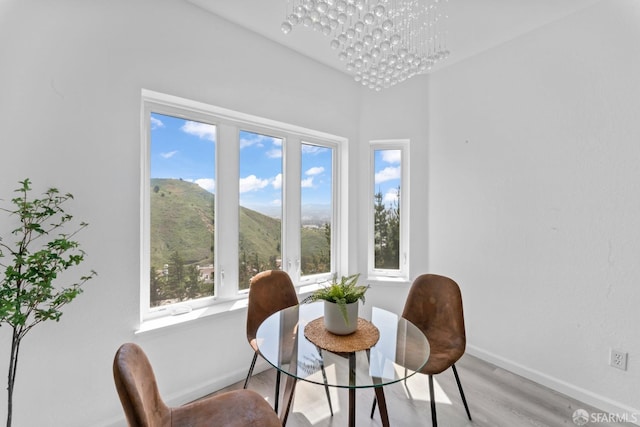 dining area featuring baseboards, a notable chandelier, and light wood-style floors