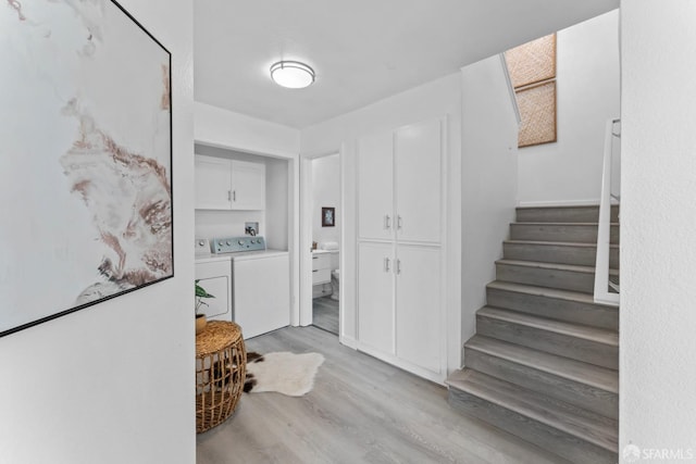 stairs featuring wood finished floors and washing machine and dryer