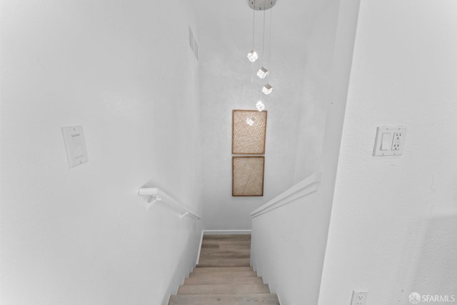 staircase with baseboards and wood finished floors