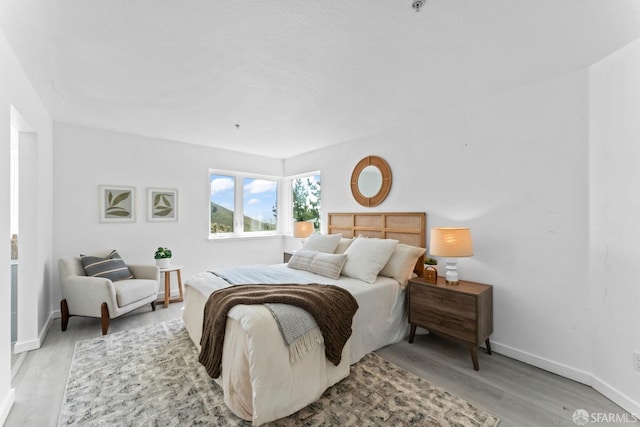 bedroom with light wood-style floors and baseboards