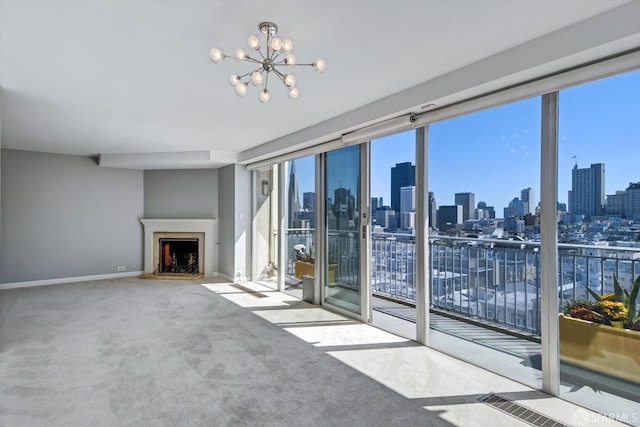 unfurnished living room featuring a wealth of natural light, a chandelier, and carpet floors