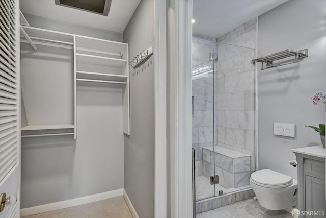 interior space with vanity, a shower with shower door, and toilet