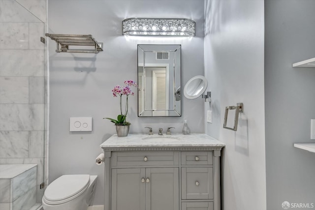 bathroom featuring a shower, vanity, and toilet