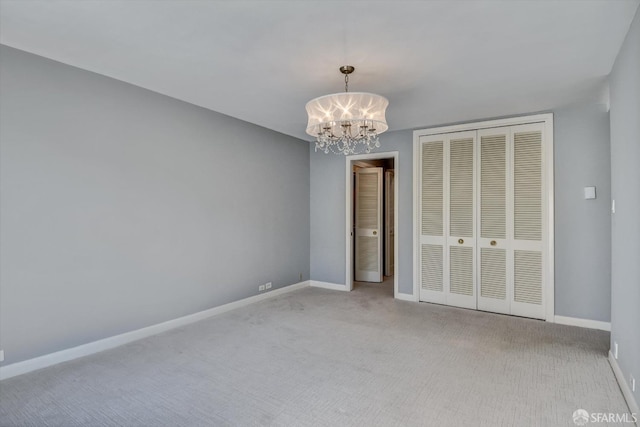 unfurnished bedroom featuring a chandelier, a closet, and light colored carpet