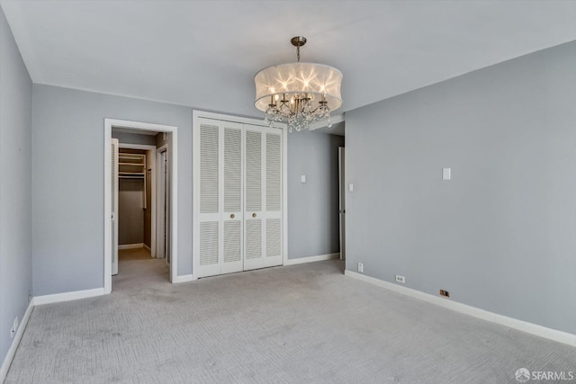 unfurnished bedroom with light carpet, a chandelier, and a closet