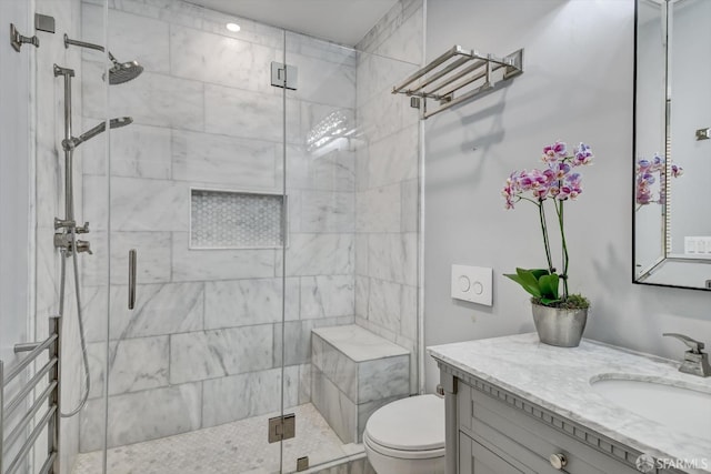 bathroom with walk in shower, vanity, and toilet