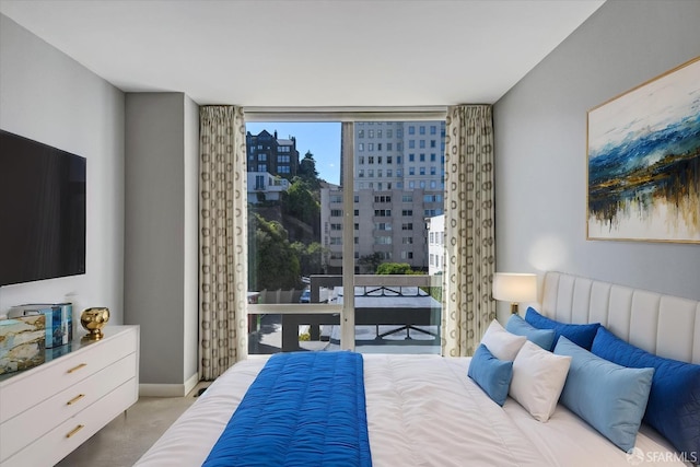 bedroom featuring light carpet and expansive windows