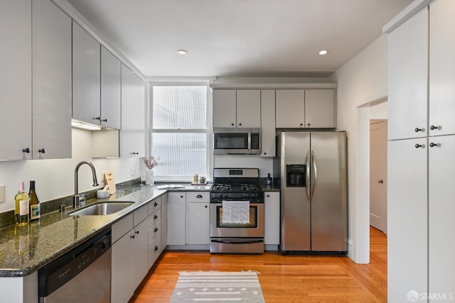 1630 Clay St Unit 4, San Francisco, CA 94109 - kitchen with stainless steel appliances, a sink, light wood-style floors, dark stone counters, and recessed lighting