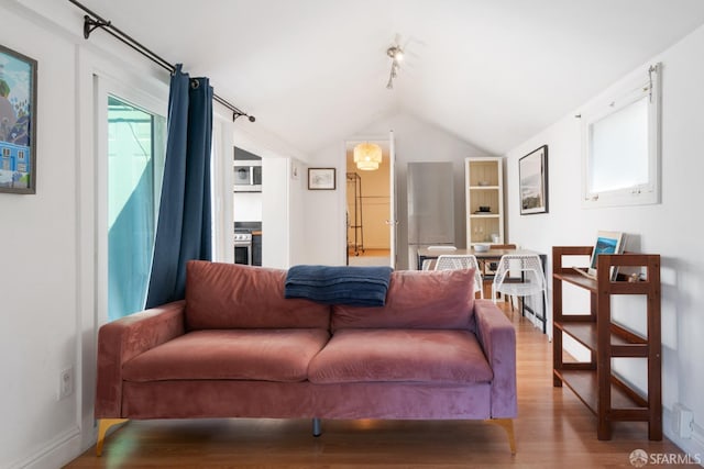 living area featuring vaulted ceiling and wood finished floors