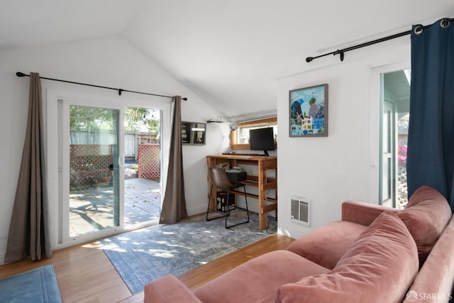 living area featuring vaulted ceiling, wood finished floors, and visible vents