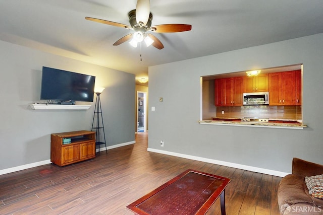 living room with dark wood-type flooring and ceiling fan