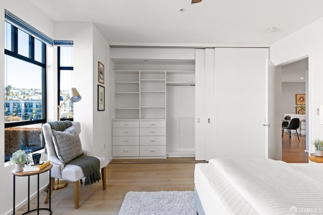 bedroom with light hardwood / wood-style flooring and a closet