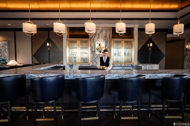 bar with stone counters and pendant lighting