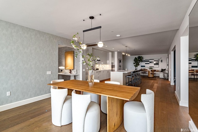 dining area with sink and dark wood-type flooring