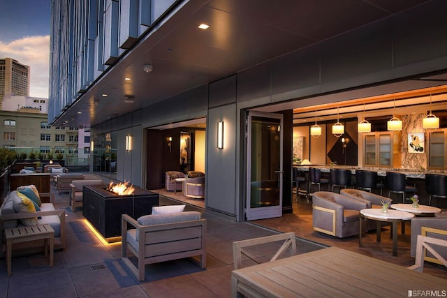 patio terrace at dusk with an outdoor living space with a fire pit