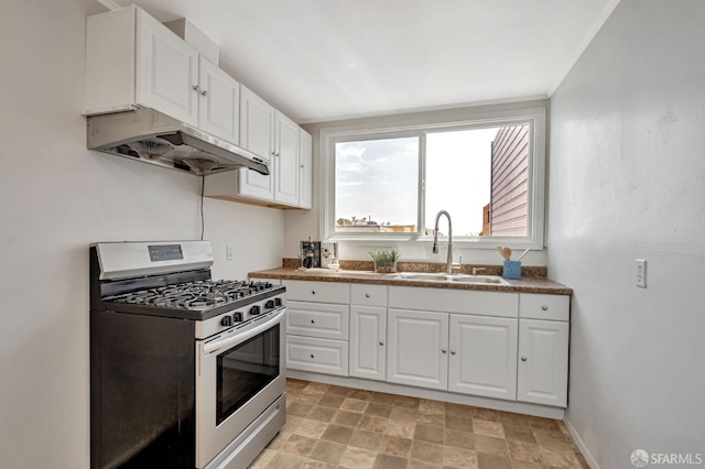 141 Cambridge St, San Francisco, CA 94134 - kitchen featuring stainless steel gas range, under cabinet range hood, a sink, white cabinetry, and stone finish floors