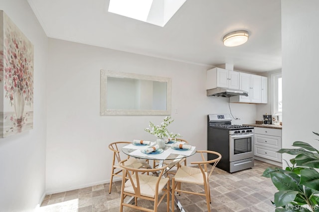 141 Cambridge St, San Francisco, CA 94134 - kitchen featuring gas stove, a skylight, under cabinet range hood, white cabinets, and baseboards