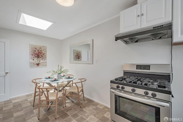 141 Cambridge St, San Francisco, CA 94134 - kitchen featuring gas stove, under cabinet range hood, white cabinetry, and baseboards