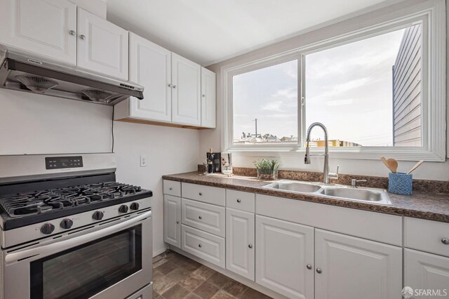 141 Cambridge St, San Francisco, CA 94134 - kitchen with stainless steel gas stove, under cabinet range hood, a sink, white cabinetry, and dark countertops