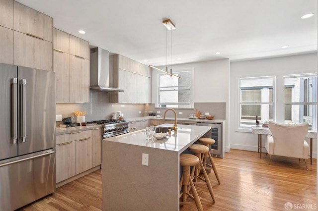 3445 Fillmore St, San Francisco, CA 94123 - kitchen with premium appliances, beverage cooler, wall chimney exhaust hood, modern cabinets, and a breakfast bar area
