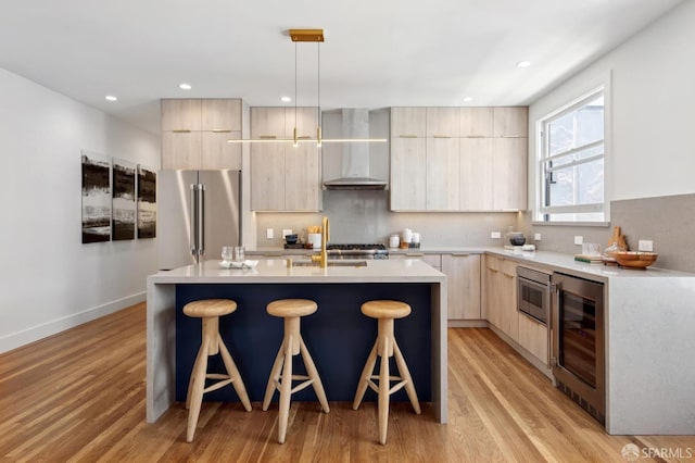 3445 Fillmore St, San Francisco, CA 94123 - kitchen featuring wall chimney exhaust hood, light brown cabinets, modern cabinets, appliances with stainless steel finishes, and recessed lighting