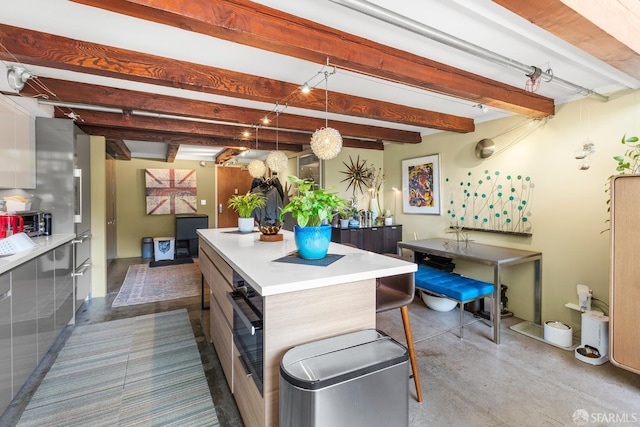 701 Pennsylvania Ave Unit 107, San Francisco, CA 94107 - kitchen featuring concrete flooring, a kitchen island, beam ceiling, light countertops, and decorative light fixtures