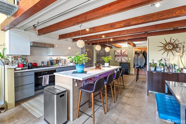 701 Pennsylvania Ave Unit 107, San Francisco, CA 94107 - kitchen featuring wall oven, finished concrete flooring, modern cabinets, light countertops, and a center island