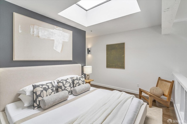 bedroom featuring hardwood / wood-style flooring and a skylight