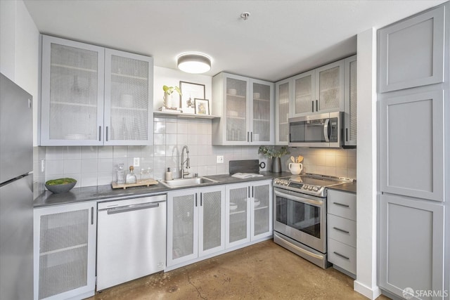 kitchen with sink, decorative backsplash, gray cabinets, and appliances with stainless steel finishes