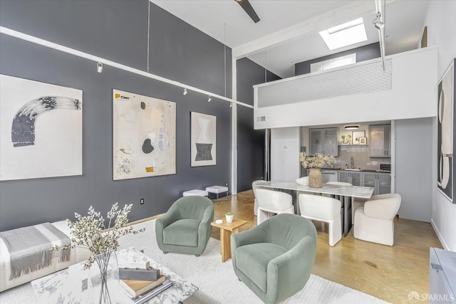 living room with a skylight, sink, and a high ceiling