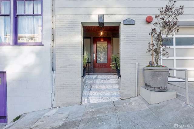 entrance to property featuring brick siding