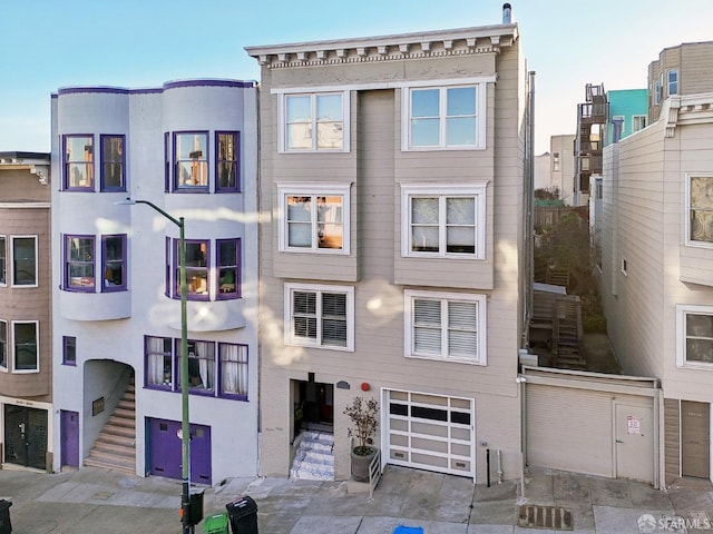 view of front facade with a garage, stairway, and cooling unit