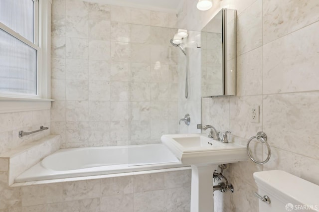 full bath featuring toilet, tile walls, and tiled shower / bath combo