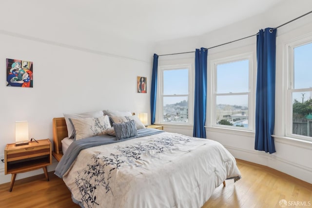 bedroom with light wood-style flooring and baseboards