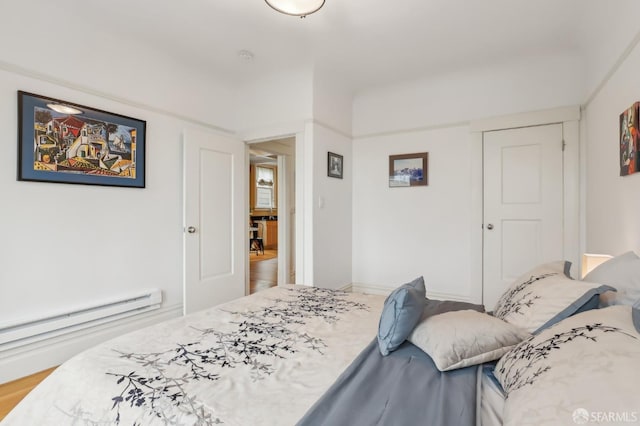 bedroom featuring baseboards, baseboard heating, and a closet