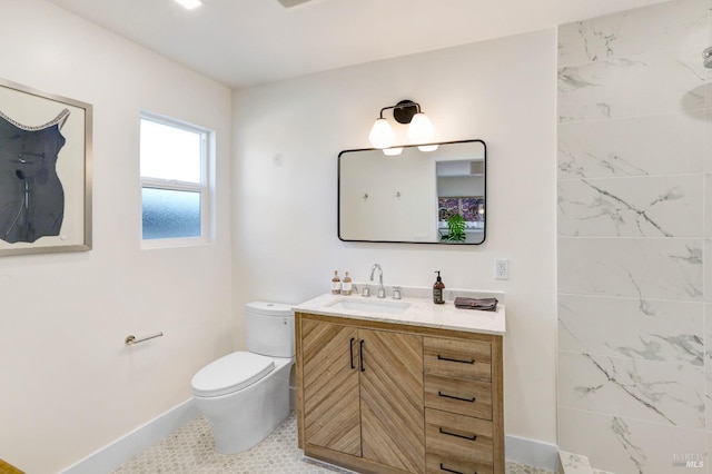 bathroom featuring baseboards, vanity, and toilet