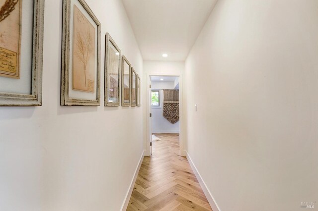 hall with baseboards and recessed lighting