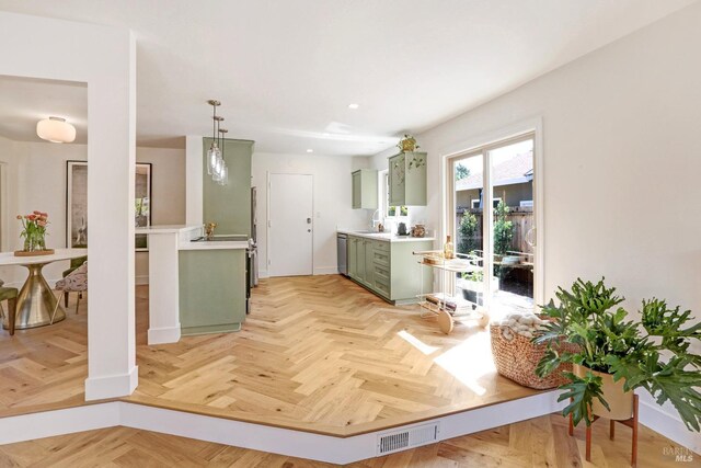 kitchen with visible vents, stainless steel dishwasher, light countertops, green cabinets, and recessed lighting
