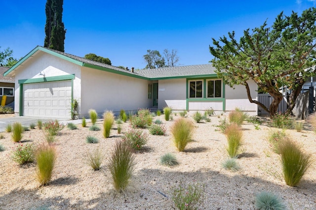 view of front of house featuring an attached garage, driveway, and stucco siding