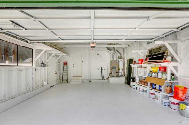 garage with strapped water heater and a garage door opener