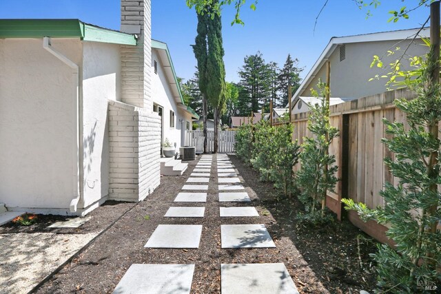 view of yard featuring fence and central air condition unit