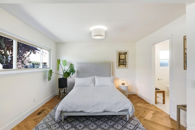 bedroom featuring baseboards and connected bathroom