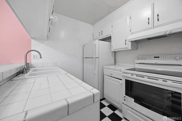 kitchen with tile countertops, sink, white cabinets, and white appliances